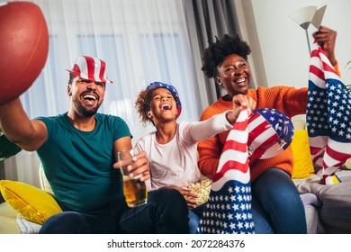 Family Watching American Football Match On Television At Home