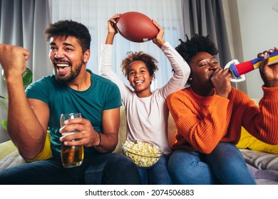 Family Watching American Football Match On Television At Home