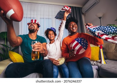 Family Watching American Football Match On Television At Home