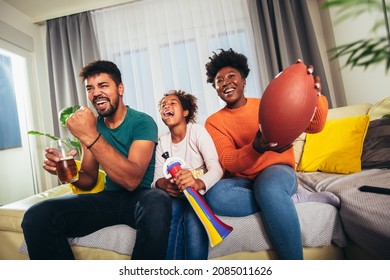 Family Watching American Football Match On Television At Home