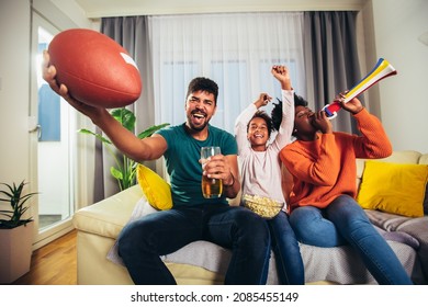 Family Watching American Football Match On Television At Home