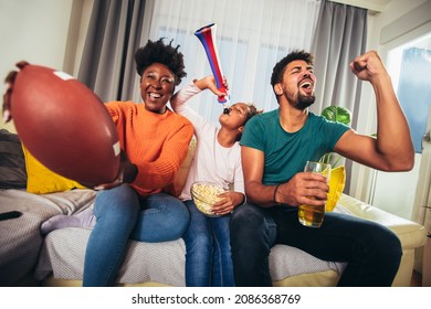 Family Watching American Football Match On Television At Home