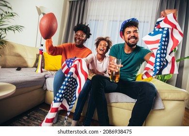 Family Watching American Football Match On Television At Home