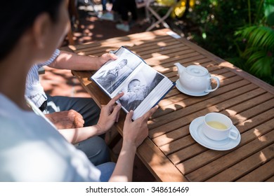 Family Watching Baby Pictures In Photo Album