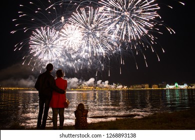 Family Watching Fireworks By The River