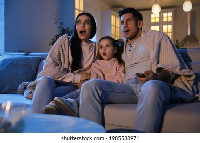 Family Watching Movie On Sofa At Night