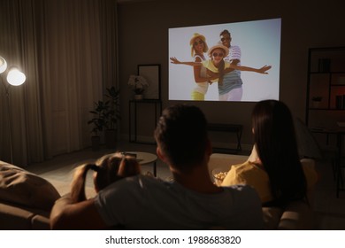 Family Watching Movie On Sofa At Night, Back View