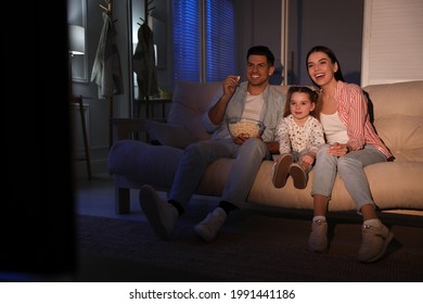 Family Watching Movie With Popcorn On Sofa At Night, Space For Text