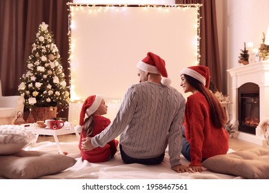 Family Watching Movie Using Video Projector At Home. Cozy Christmas Atmosphere