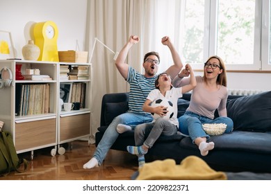 Family Watching Soccer Game On Tv At Home