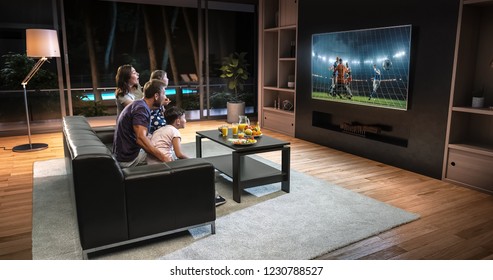A family is watching a soccer moment on the TV and celebrating a goal, sitting on the couch in the living room. The living room is made in 3D. - Shutterstock ID 1230788527