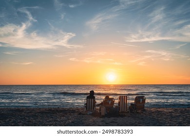 А family is watching sunset on a beach in Venice, Florida - Powered by Shutterstock