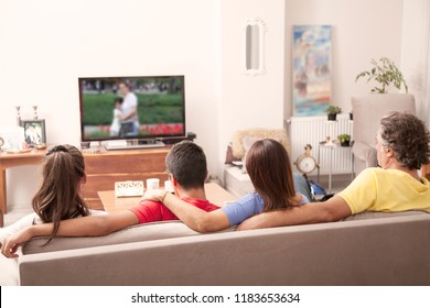 Family Watching Television At Home