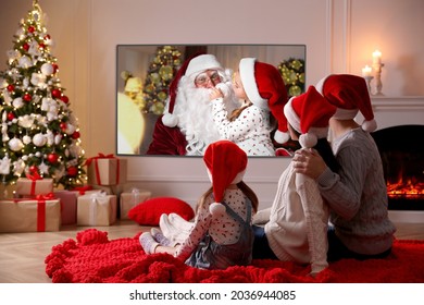 Family Watching TV Movie In Room Decorated For Christmas