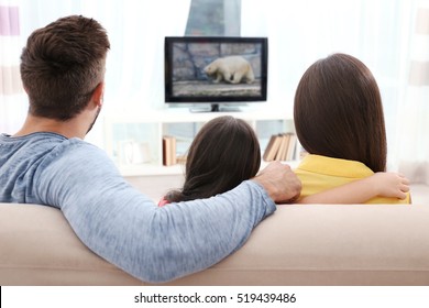 Family watching TV on couch