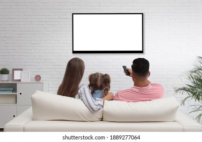 Family watching TV on sofa at home, back view - Shutterstock ID 1889277064