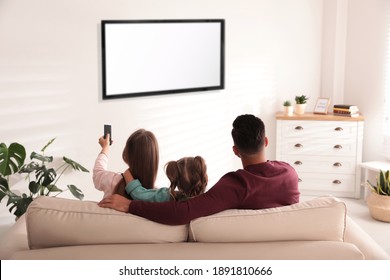 Family Watching TV On Sofa At Home, Back View