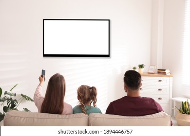 Family watching TV on sofa at home, back view - Shutterstock ID 1894446757