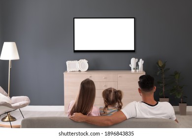 Family Watching TV On Sofa At Home, Back View