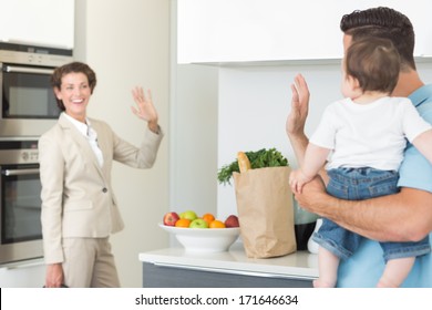 Family waving goodbye to smiling businesswoman - Powered by Shutterstock