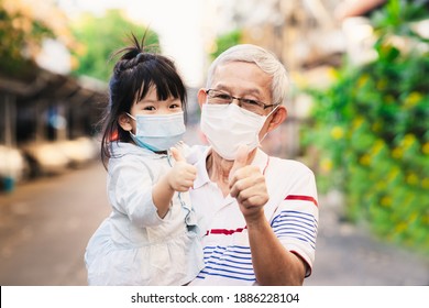 Family wear mask to prevent spread of coronavirus. Grandfather and grandchildren raised their thumbs up, showing great expression. Strong family with elderly and young child to fight spread of disease