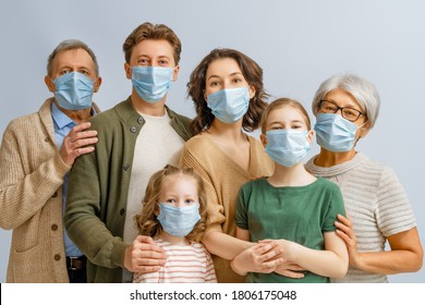 Family is wearing facemasks during coronavirus and flu outbreak. Virus and illness protection, quarantine. COVID-2019. Taking on or taking off masks. People on white wall background.