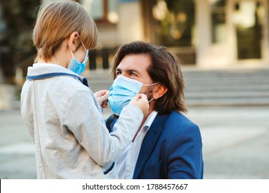 Family wearing safety masks for protection during the quarantine. Coronavirus outbreak. Dad putting on a protective mask on his son's face. Medical mask to prevent coronavirus. Coronavirus pandemic - Powered by Shutterstock