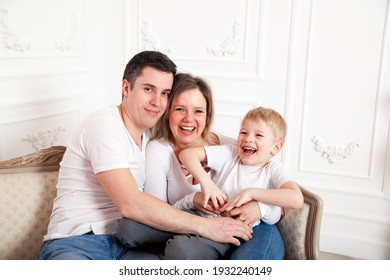 Family in white and jeans on   light sofa against   white wall