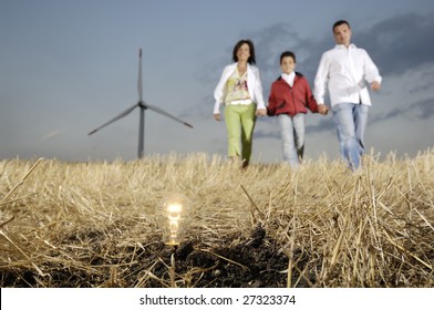 Family and wind turbines; go for a walk between wind turbine; light bulb in the ground, concept of ecology and alternative energy - Shutterstock ID 27323374
