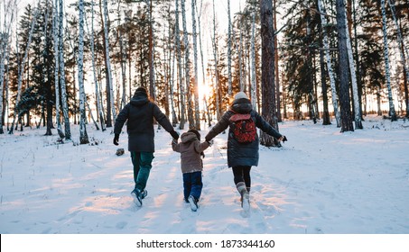 Family In Winter Forest At Sunset 