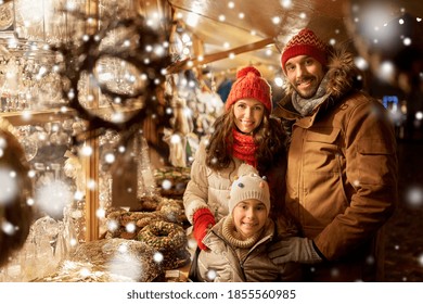 Family, Winter Holidays And Celebration Concept - Happy Mother, Father And Little Daughter At Christmas Market On Town Hall Square In Tallinn, Estonia Over Snow