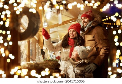 family, winter holidays and celebration concept - happy mother, father and little daughter at christmas market on town hall square in tallinn, estonia - Powered by Shutterstock