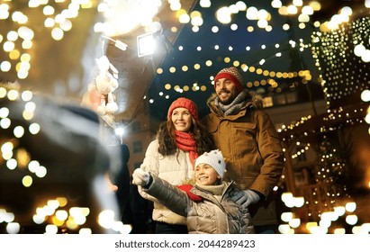 family, winter holidays and celebration concept - happy mother, father and little daughter at christmas market on town hall square in tallinn, estonia - Powered by Shutterstock