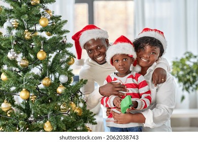 family, winter holidays and people concept - happy african american mother, father and little son with toy cars at home on christmas