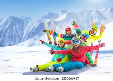 Family in winter mountains. Ski and snow vacation fun. Group of friends on ski and snowboard. Skiing and snowboarding in Swiss Alps. Active and safe sport for parents and kids. Children on slope.