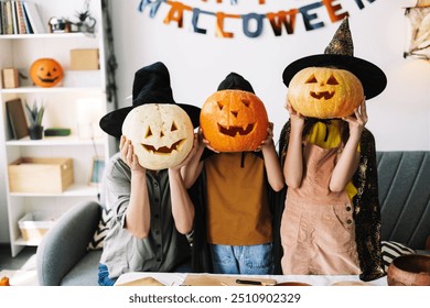 Family in witch hats and carved pumpkins, having fun at home for halloween. Smiling, crafting, and decorating together, creating special memories - Powered by Shutterstock