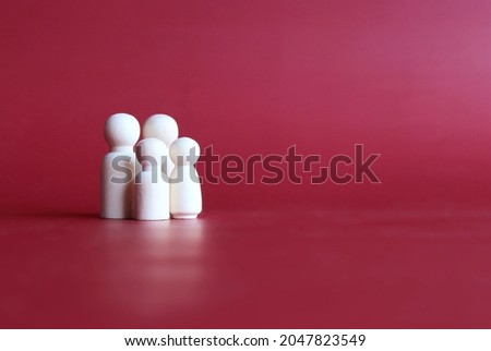 Family wooden dolls on red background with copy space