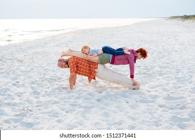 Family workout - father, mother and child doing plank exercise on beach. Man, woman and kid boy practicing yoga pose, working out together on seaside in the morning. Healthy outdoor activities. - Powered by Shutterstock