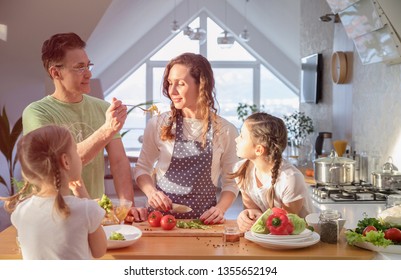 Family With Young Children Cooking Together In The Kitchen At Home