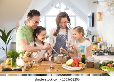 Family With Young Children Cooking Together In The Kitchen At Home