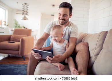 Family,childhood, Fatherhood, Technology And People Concept - Happy Father And Son With Tablet  Playing Or Having Video Chat At Home.