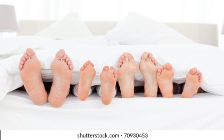 Family's Feet In The Bed