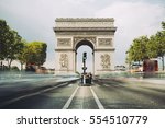 Famous avenue Champs-Elysees and the Triumphal Arch, symbol of the glory and historical heritage. Iconic touristic architectural landmark of Paris, France. Tourism and travel concept. Long exposure