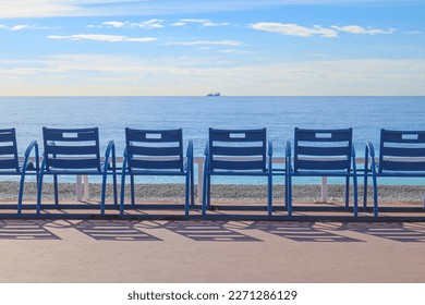 Famous blue chairs on the Promenade des Anglais in Nice, overlooking the Mediterranean Sea