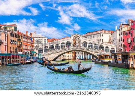 Famous buildings, gondolas and monuments by the Rialto Bridge of Venice on the Grand Canal, Italy