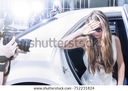 famous celebrity getting out of a limousine in front of a red carpet event, with flashing paparazzi 