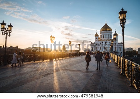 Famous christian landmark in Russia - Christ the Savior cathedral at sunset. Golden sunset lights on a bridge in Moscow, outdoor autumn in Russia. Christ the Savior cathedral, outdoor Moscow landscape