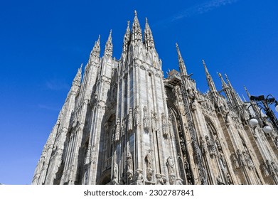 Famous church Milan Cathedral Duomo di Milano with Gothic spires and white marble statues. Top tourist attraction on piazza in Milan Lombardia Italy Wide angle view of old Gothic architecture and art - Powered by Shutterstock