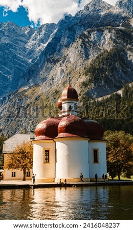 The famous church Saint Bartholomew with reflections and the Watzmann east face in summer at Lake Koenigssee, Schoenau, Berchtesgaden, Bavaria, Germany