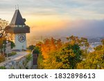 The famous clock tower on Schlossberg hill, in Graz, Styria region, Austria, at sunrise. Beautiful foggy morning over the city of Graz, in autumn